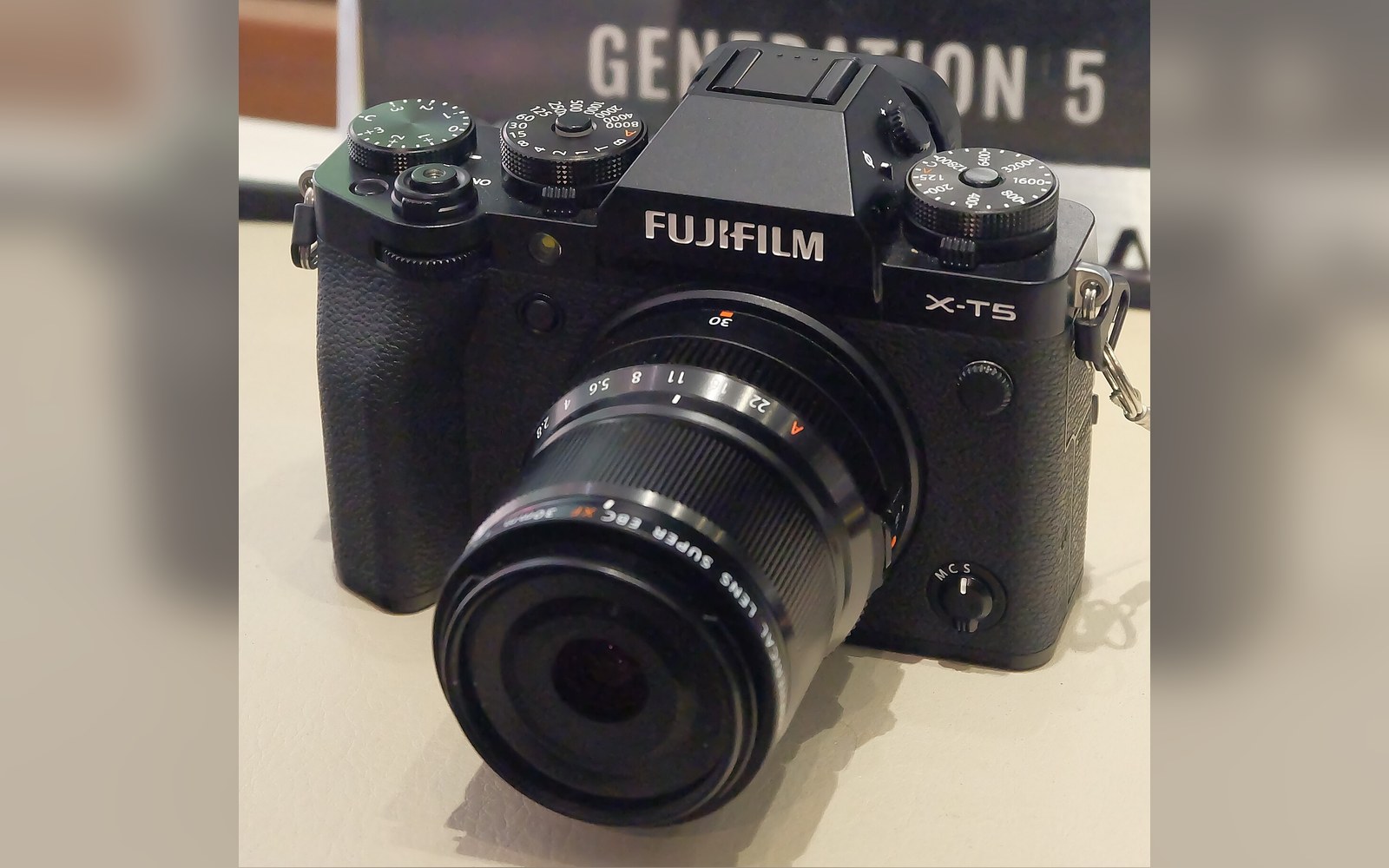 Fujifilm X-T5 mirrorless camera with attached zoom lens on a display table
