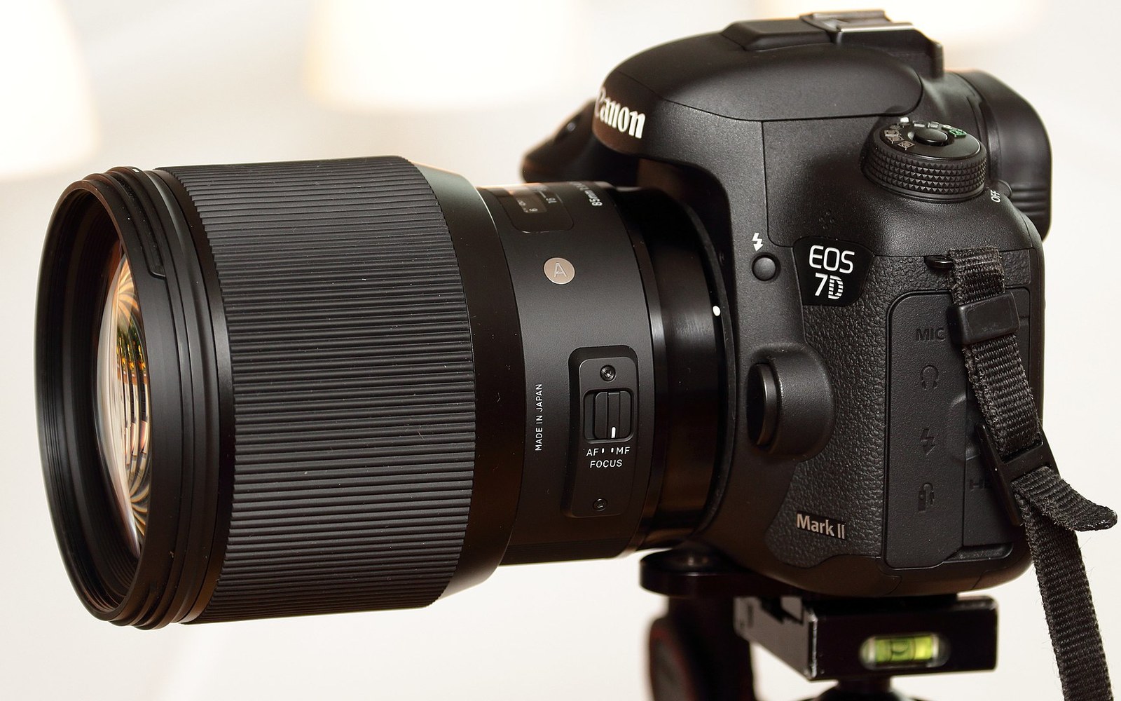 Rear element and mount contacts of a Sigma Art prime lens, resting on a grey cloth, the L-mount bayonet ring in sharp focus